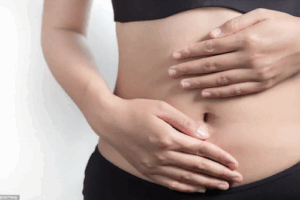 photo gros plan sur deux mains sur ventre plat et mince de femme 
