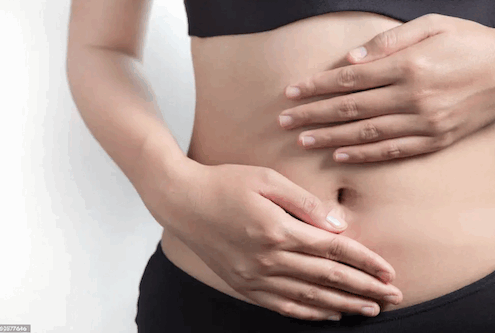 photo gros plan sur deux mains sur ventre plat et mince de femme
