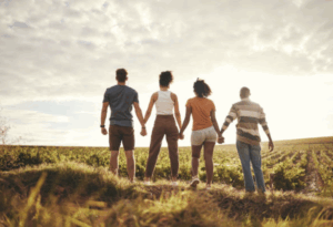 groupe de quatre personnes vus de dos se tenant la main 