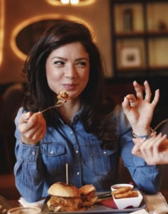 Femme_souriante_deguste_un_burger