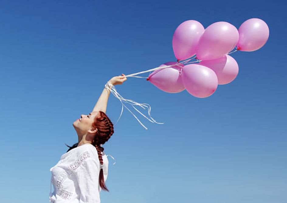 Femme tient ballons roses et lache prise