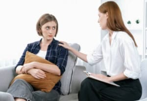 femme triste avec troubles alimentaires réconfortée par thérapeute bienveillant