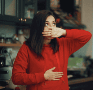femme se tient la bouche et le ventre