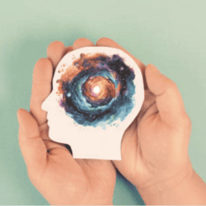 Deux mains tenant un profil en papier représentant le cerveau et l'hypnose.